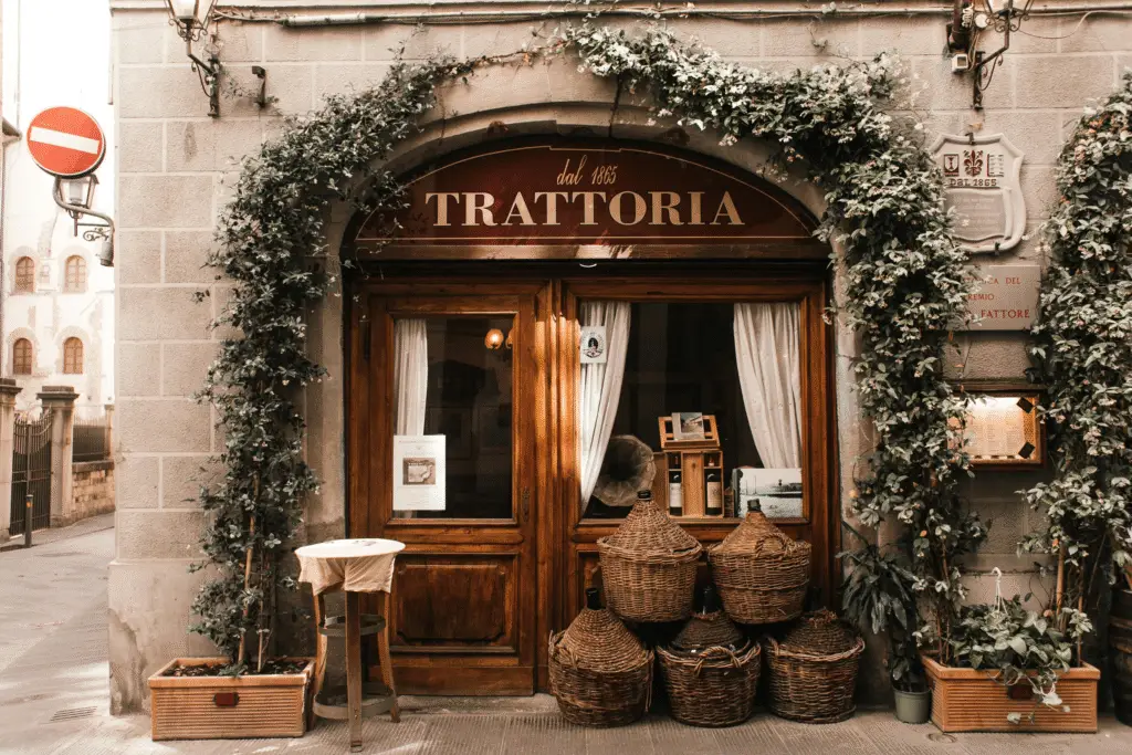 Rustic entrance of an authentic Roman trattoria in Italy, perfect for budget luxury travel dining experiences.