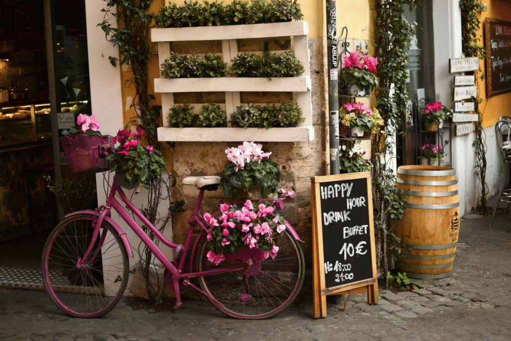 Charming Rome café with a pink flower bike, chalkboard menu, and happy hour aperitivo scene